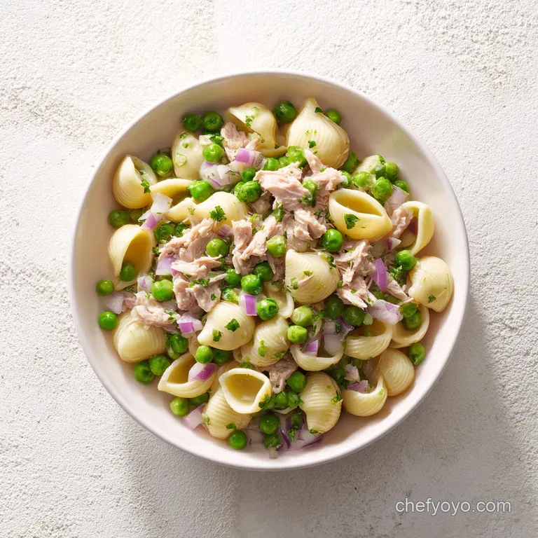 A white ceramic bowl filled with creamy pasta, topped with a sprig of fresh parsley and cracked black pepper.